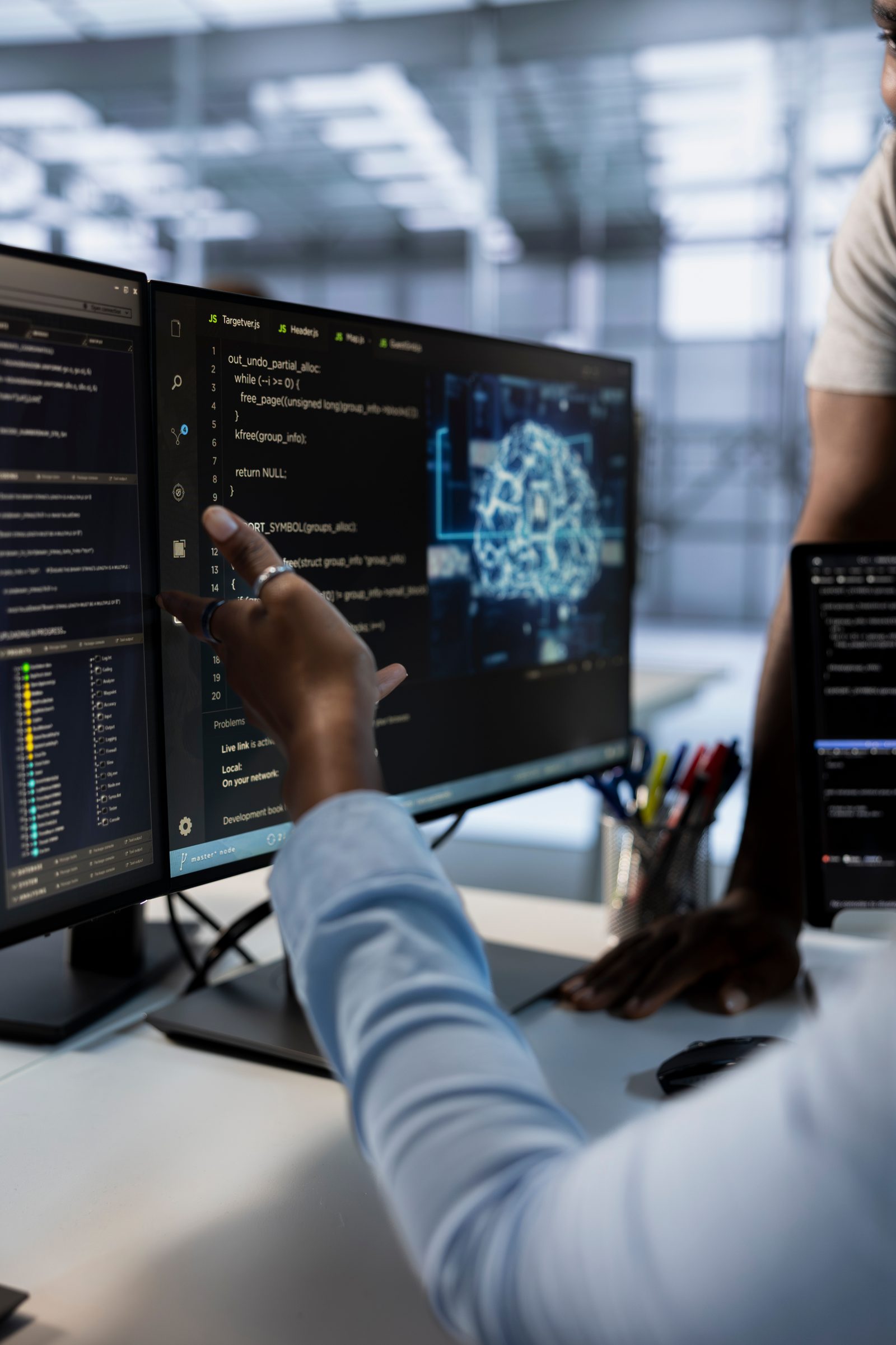 Data engineers reviewing a pipeline on dual monitors