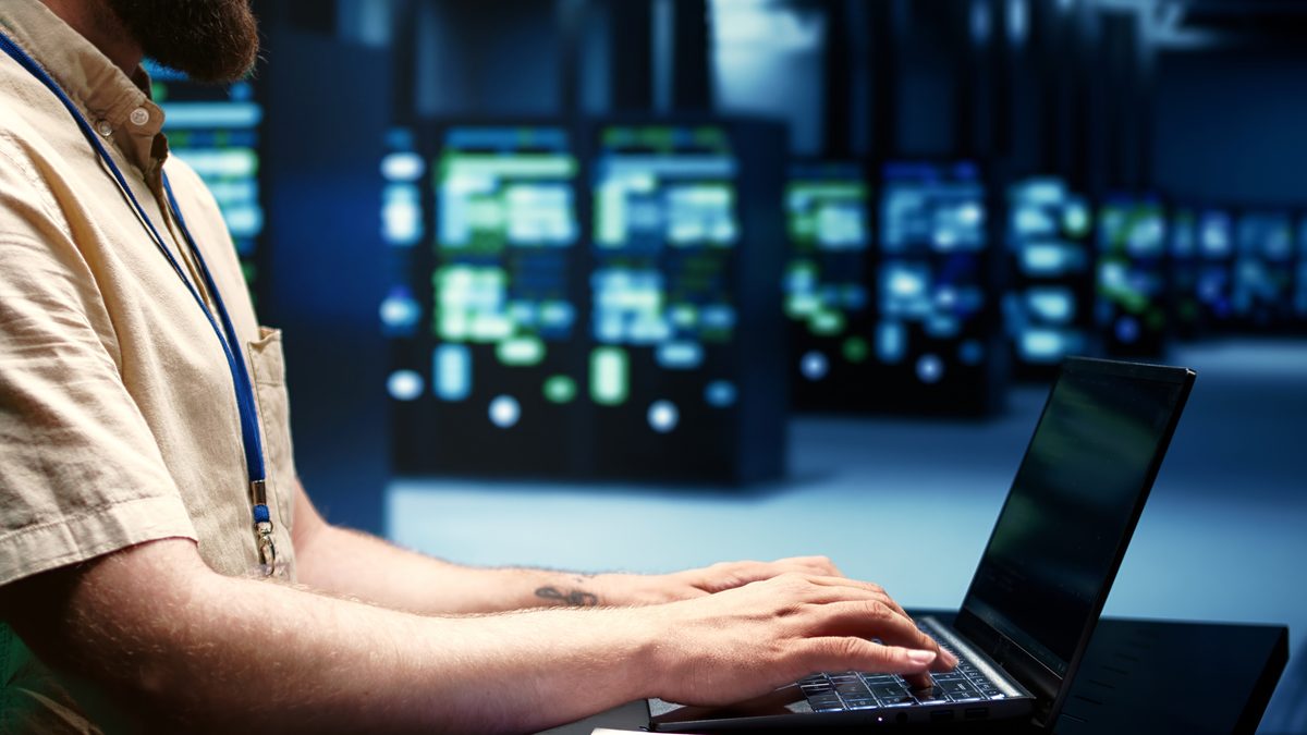 A data engineer working on a laptop in a modern office