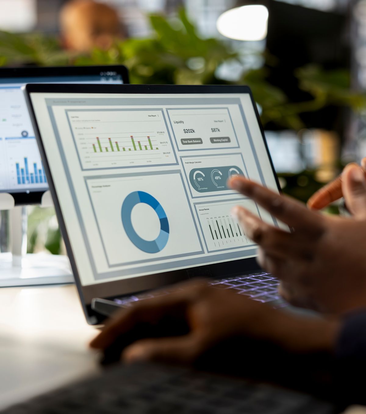 A data analyst working with dashboards on a laptop