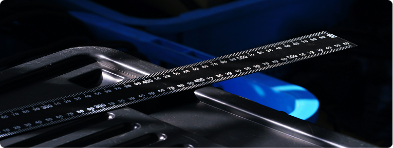 A precision ruler laid across machined metal parts